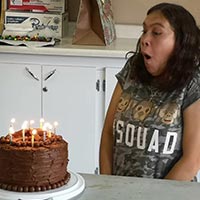 woman having fun blowing out her birthday cake