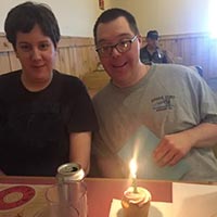 Two people smiling with cupcakes