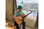 A man playing the guitar on St. Patty's Day