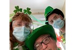 Three people wearing fun St. Patrick's Day headwear